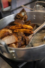 A hot pan with oil sizzling as fritada cooks, perfect for food, cooking, cuisine, and traditional dishes themes.