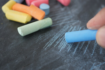 Colorful chalks create art on a blackboard surface