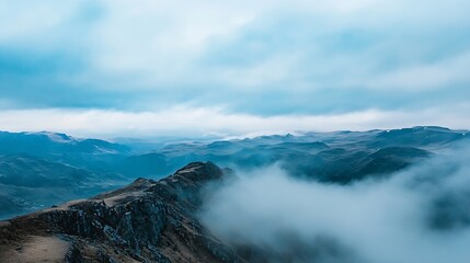Obraz premium Breathtaking panoramic view of misty mountains under a moody sky with vast landscapes stretching into the horizon : Generative AI