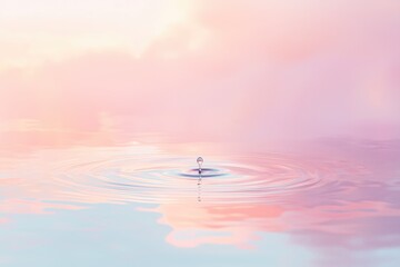 A single water drop creates calming ripples on a pastel colored water surface.