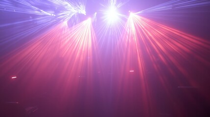 Obraz premium A dramatic concert light display with red and blue laser lights glowing through thick stage fog.
