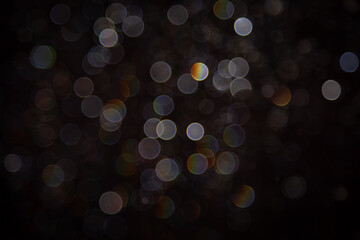 Abstract bokeh lights with colorful circles on dark background, creating a dreamy and festive atmosphere