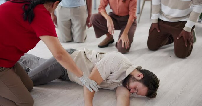 First aid, volunteer and man with people in workshop for learning, healthcare and demonstration. Paramedic course, instructor and teaching with person in class for emergency, rescue and cpr technique