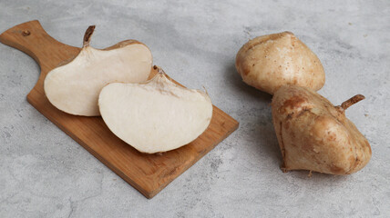 Fresh Jicama or bengkoang, white tubers that can be eaten as salad or for face masks. Isolated on grey background. Prebiotic food, gut health.
