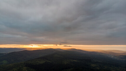 Aerial Flight Over Majestic Mountains And Dense Forests, Shrouded In Misty Clouds With Rainfall, Creating A Dramatic And Serene Landscape Of Untouched Wilderness.