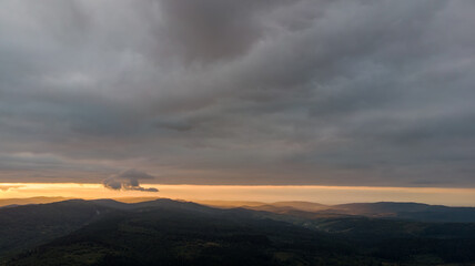 Aerial Flight Over Majestic Mountains And Dense Forests, Shrouded In Misty Clouds With Rainfall, Creating A Dramatic And Serene Landscape Of Untouched Wilderness.	
