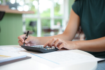 Businesswoman Accountant analyzing investment charts Invoice and pressing calculator buttons over documents. Accounting Bookkeeper Clerk Bank Advisor And Auditor Concept.