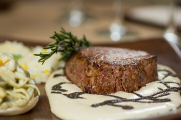 Juicy roasted beef steak with rosemary white sauce, a mouthwatering close-up shot.