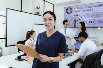 A diverse team of doctors and nurses work together in a hospital office and talk to each other....
