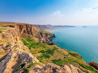Obraz premium Scenic coastline of oman featuring rocky cliffs and calm turquoise waters under a clear blue sky