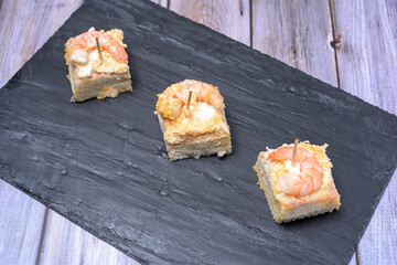prawn canape on black slate tray on wooden table