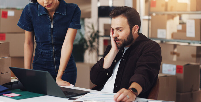 Man, laptop and stress for logistics, boxes and mistake with order for lost stock and woman in warehouse. People, computer and supply chain management with distribution error at shipping storage