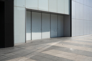 Modern building facade with large door and striped pavemen