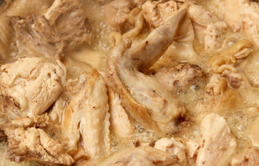A pot of chicken is cooking in a pan