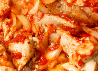 A plate of food with a lot of red sauce and onions