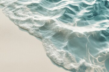 Gentle ocean waves on sandy beach; sunlit turquoise water