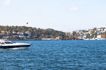 Obraz premium Watercraft idea concept. Luxury yacht sailing on the Bosphorus. Motor yacht on the blue sea. Horizontal photo. Landscape.