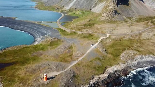 Stunning view of Hvalnes in Iceland, showcasing dramatic coastal mountains, serene blue waters, rugged terrain, and winding roads. A breathtaking blend of nature&rsquo;s raw beauty and tranquility