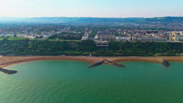 Folkestone shoreline where craggy outliers form V-shape structure on golden sand
