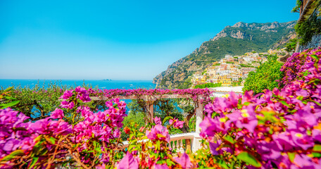Obraz premium Positano coastline in south of Italy, vertiginous cliffs adorned with colorful villages, turquoise waters. Small town Positano on Amalfi Coast near Neapol, Italy