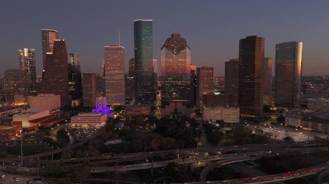 Cinematic aerial shot of Downtown Houston vibrant skyline at dusk, beautifully showcasing stunning architecture, lively city life, and the mesmerizing blend of lights and shadows, Houston, Texas, USA