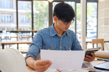Architect working on blueprints at a modern workspace