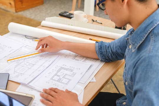 Architect working on blueprints at a modern workspace