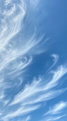 Wispy white clouds dance across vibrant blue sky