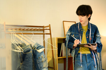 Creative designer using digital tablet working on new collection in a stylish studio