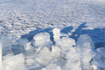 Stacked ice shards on a frozen landscape in sunlight. Winter landscape on sunny day, coastline of Baltic sea