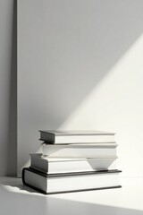 Stack of Blank Books in Sunlight Against a White Wall