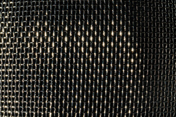 Monochrome texture of a shiny metal colander or grate. Abstract background.