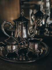 An antique vintage tea set - a teapot, a cup and a sugar bowl on a metal tray