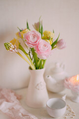 Soft Pastel Ranunculus and Yellow Roses in a Glass Vase