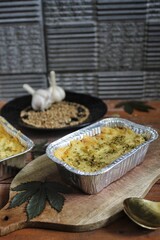 Delicious mashed potatoes bolognese in an aluminum foil bowl