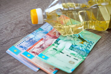 Sunflower oil and tenge banknotes on the table.