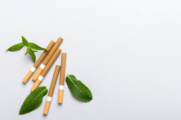 Menthol cigarettes and fresh mint leaves on colored background, Many cigarettes stacked together top view flat lay