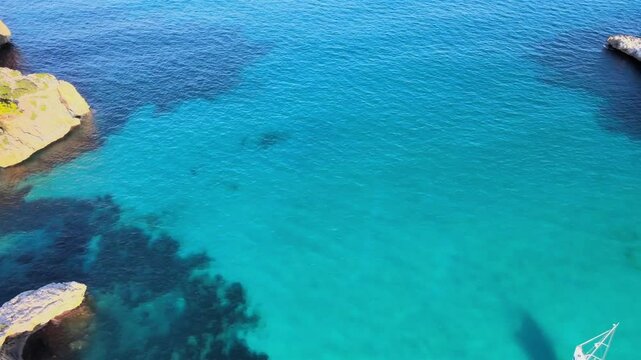 Experience the serene beauty of Cala Varques with its clear turquoise waters and rocky shoreline. Perfect for relaxation and enjoying the Mediterranean sun. Captivating views await.