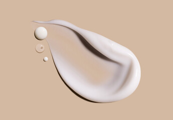 smear of creamy white texture cosmetic sample close up on beige background