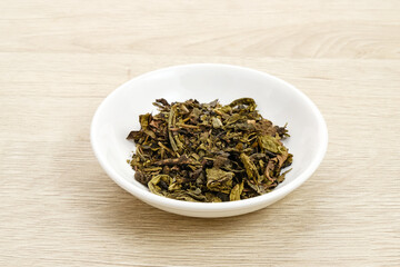Dried tea leaves on bowl, copy space
