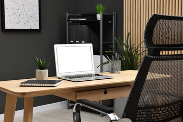 Comfortable workplace with modern laptop on wooden table indoors