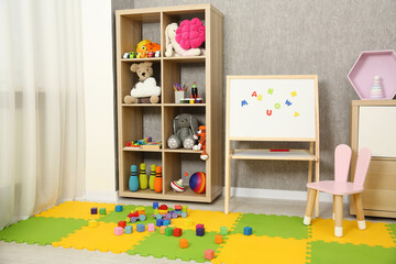 Beautiful kid's room interior with toys, whiteboard and stylish furniture