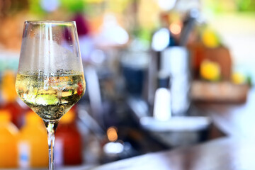 a glass of white wine served in a restaurant, abstract background of a summer restaurant