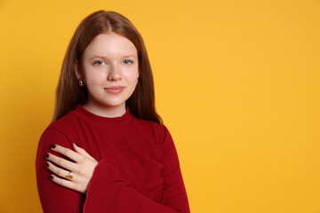Fototapeta premium Teenage girl wearing stylish jewellery on yellow background, space for text