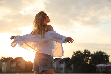Young woman with beautiful blond hair outdoors at sunset