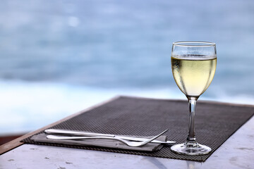 a glass of white wine on the background of the sea relaxing by the sea with wine