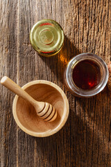 jar of honey dipper on wooden background