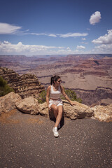Close-up of a seated woman and behind her the views of the wonderful Grand Canyon of the Colorado River in the United States.