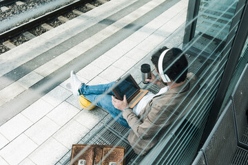 Man with basketball using tablet PC at station platform