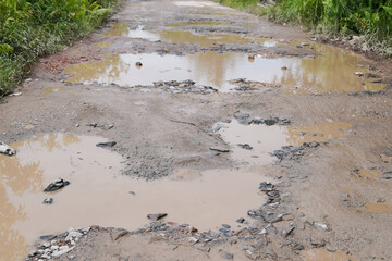Damaged potholed roads that are flooded after rain. hampering village transportation access to the city. Kubu Raya, West Kalimantan - December 14, 2024
